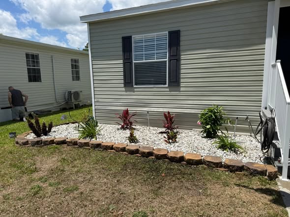 New white rock bed with natural stone border and fresh plantings