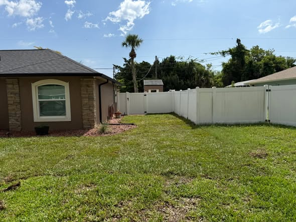Cleaned up side yard along a white vinyl privacy fence